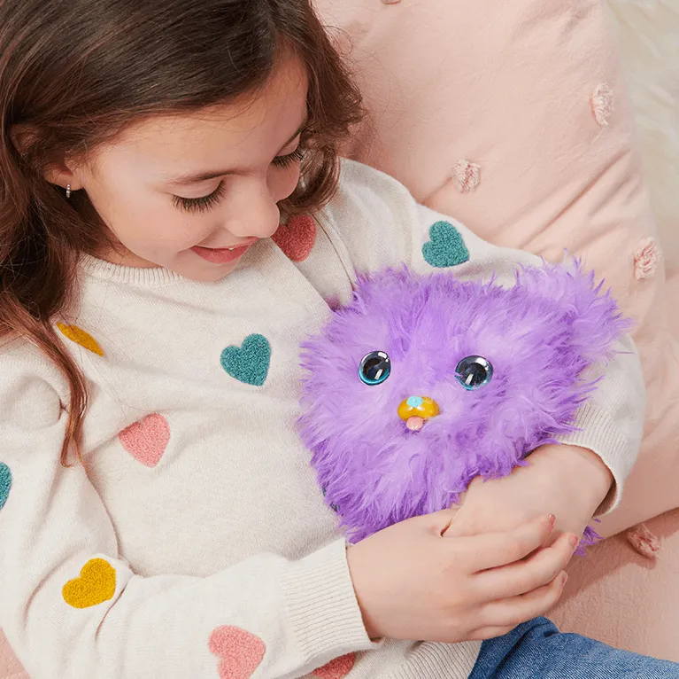 A child cuddling a Fur Fluff, a fluffy purple ball with a puppy face.